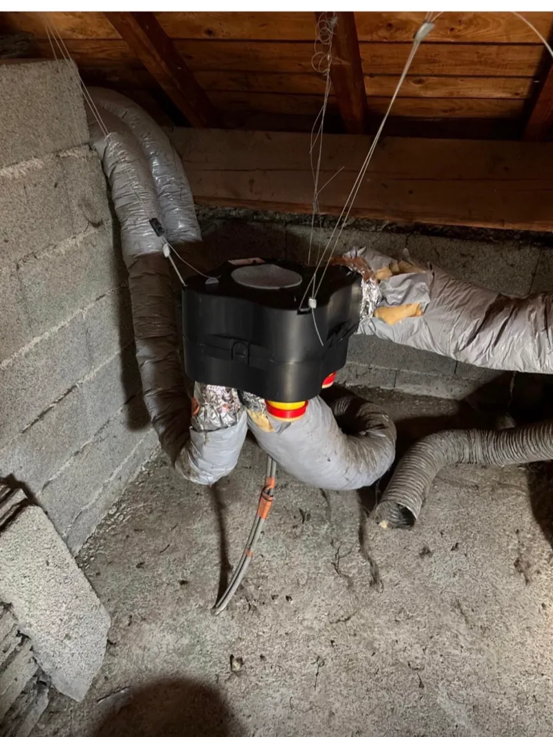 Caisson de VMC et gaines isolées installés dans des combles